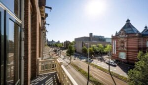 Uitzicht vanaf een balkon op de Paulus Potterstraat in Amsterdam met zicht op het Van Gogh Museum en het opvallende gebouw van de Koninklijke Industrieele Groote Club.